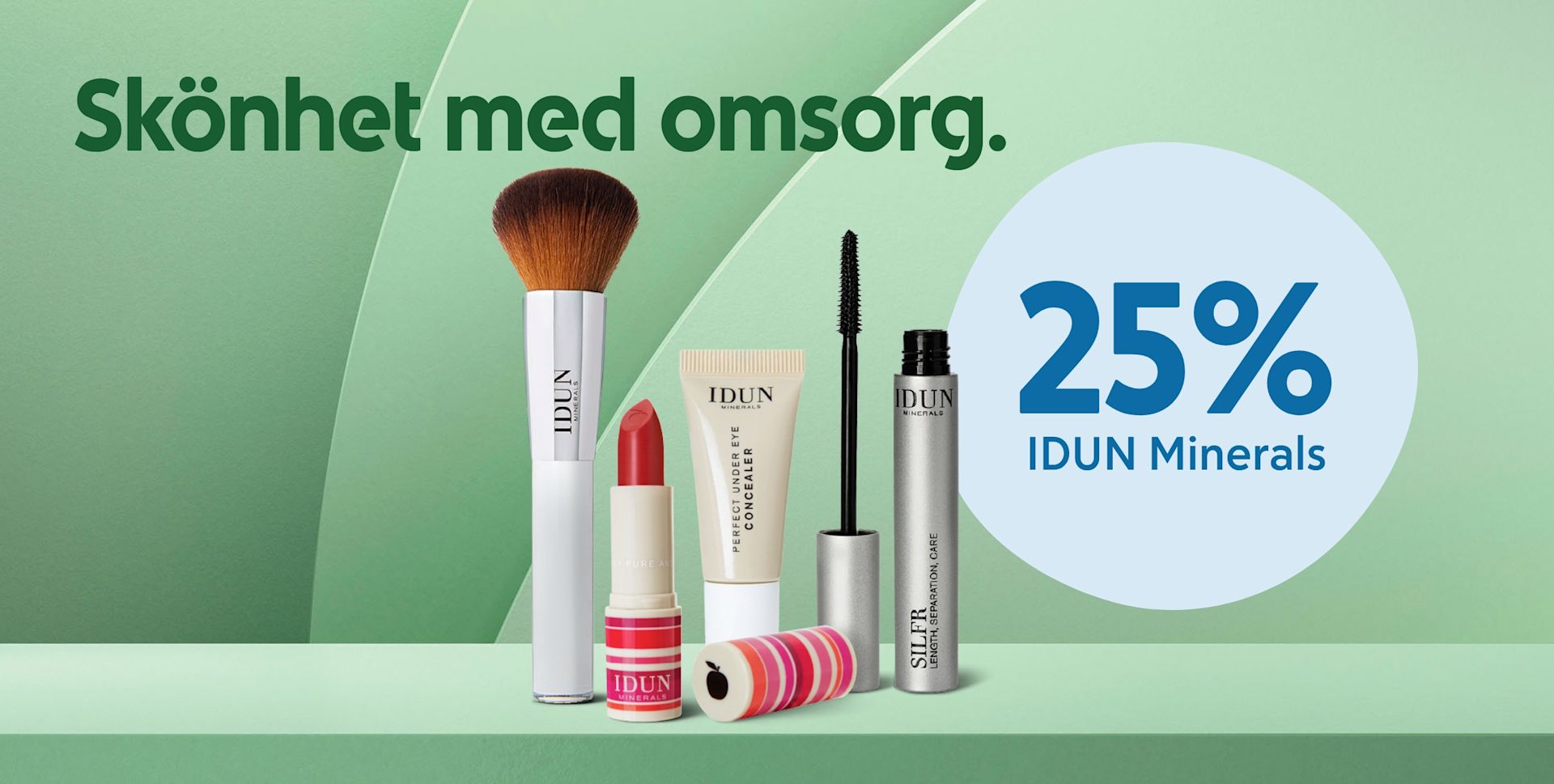 Sminkborste, rött läppstift, concealer och mascara från IDUN Minerals uppställda på grön yta med texten Skönhet med omsorg och 25% IDUN Minerals i blå cirkel.