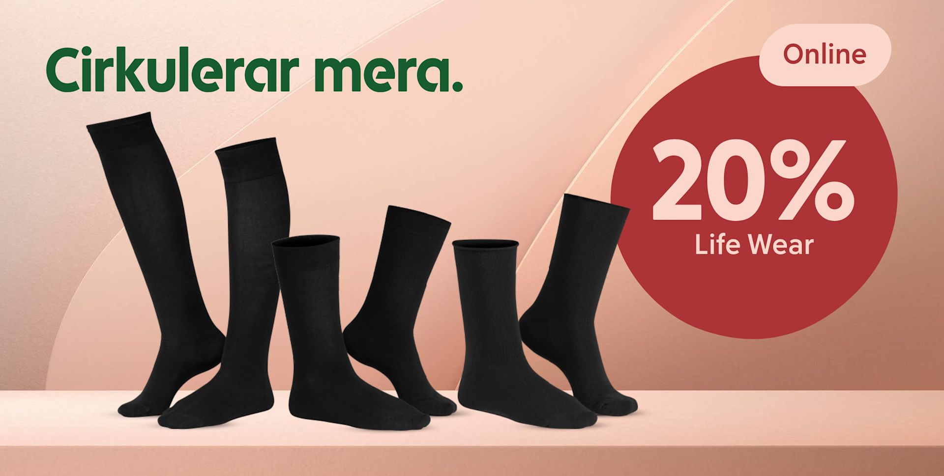 Sex par svarta strumpor visas på en hylla med text om 20% rabatt på Life Wear online mot en beige bakgrund.