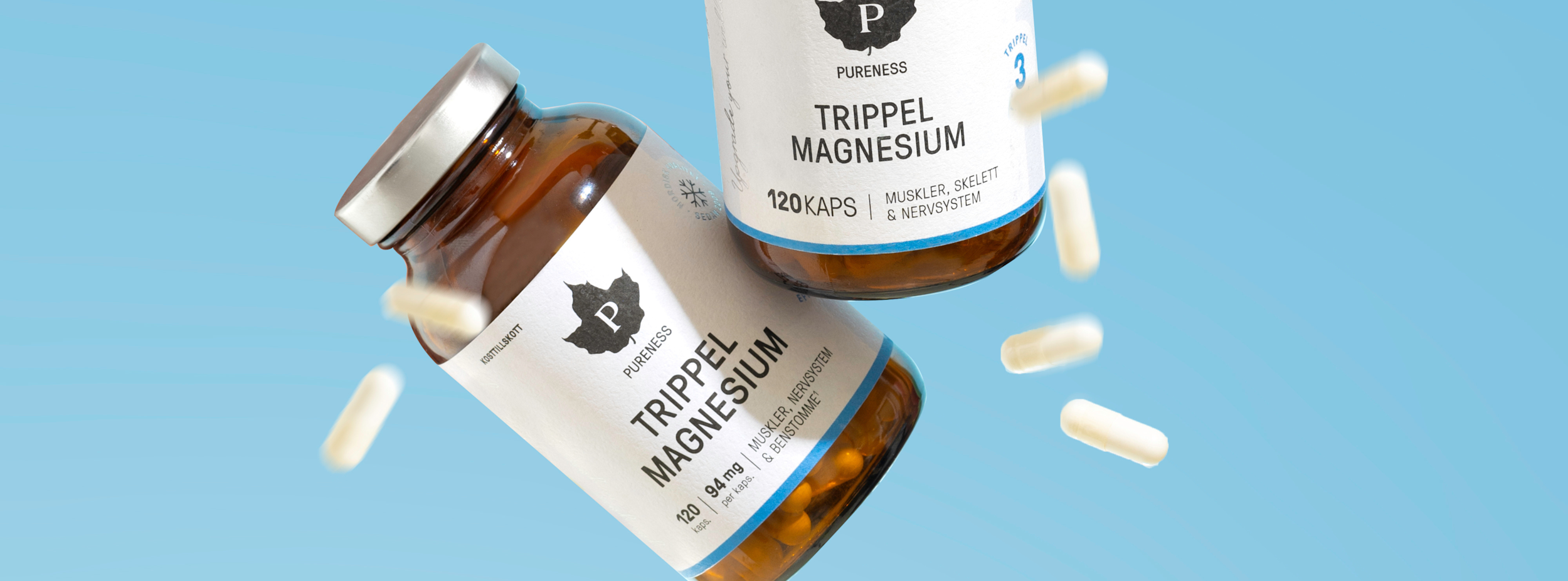 Två burkar Pureness Trippel Magnesium kosttillskott svävar mot blå bakgrund, omgivna av vita kapslar.