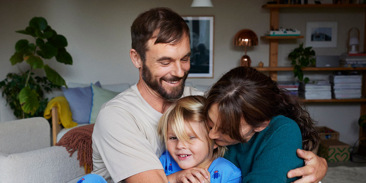 Familj kramas i hemmet.