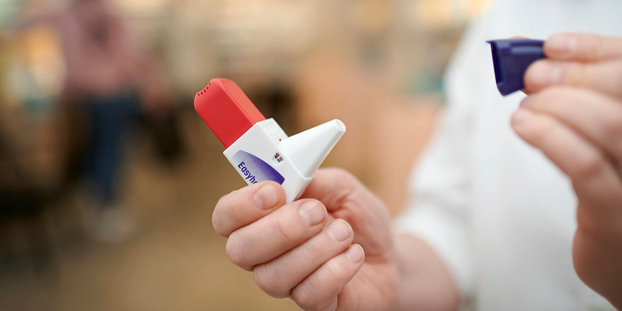 Inhalator, modell easyhaler hålls upp och skyddslocket är borttaget.